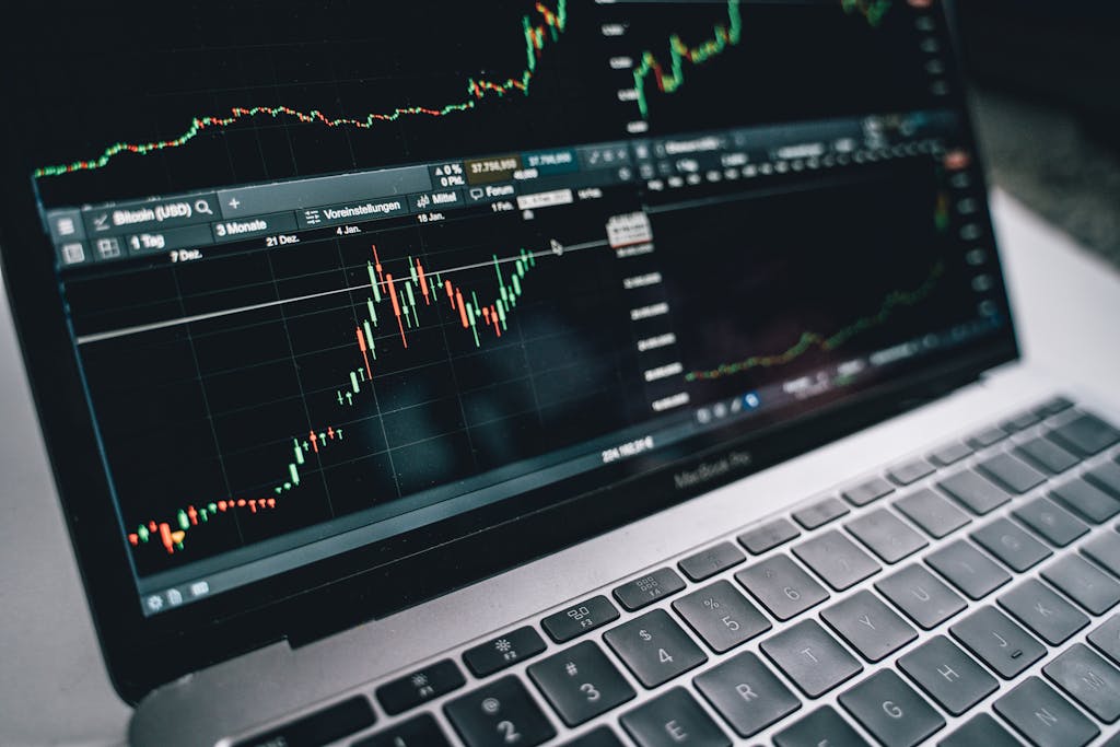 Black and Silver Laptop with Stock Market Display on Screen